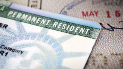 A Green Card lying on an open passport, close-up, full frame